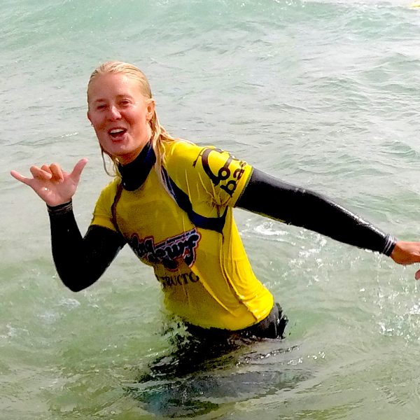 amy super stoked surf instructor in the sea in mawgan porth beach north cornwall, near newquay